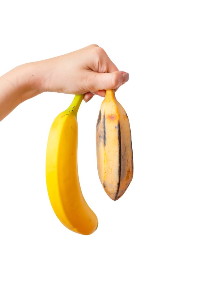 Concept of a potency. Compare of small and big penis. Woman hands holding two types of banana