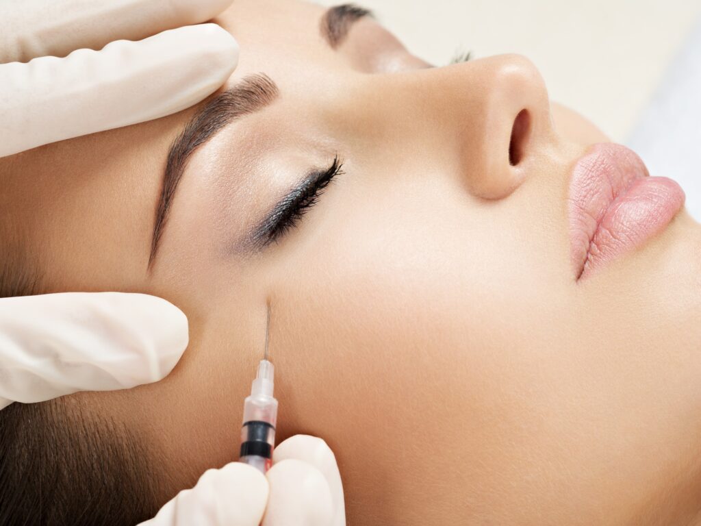 Woman getting cosmetic injection of botox near eyes